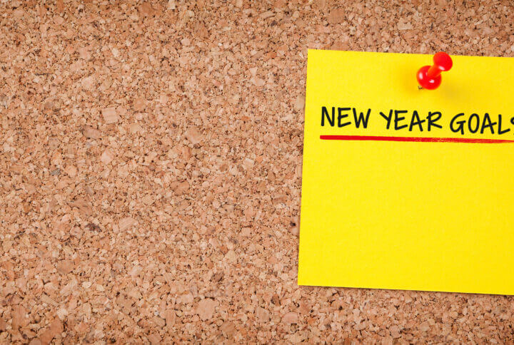 post-it note on a corkboard that reads new year goals