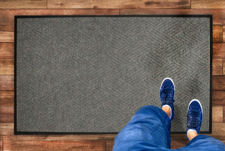 a person standing on a waterhog mat with diamond pattern