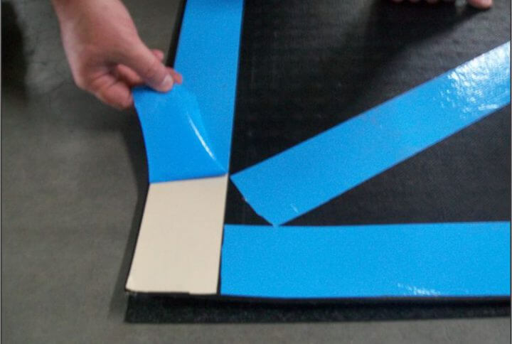 person peeling away blue tape