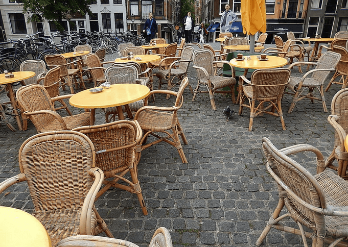 a group of outdoor dining tables and chairs